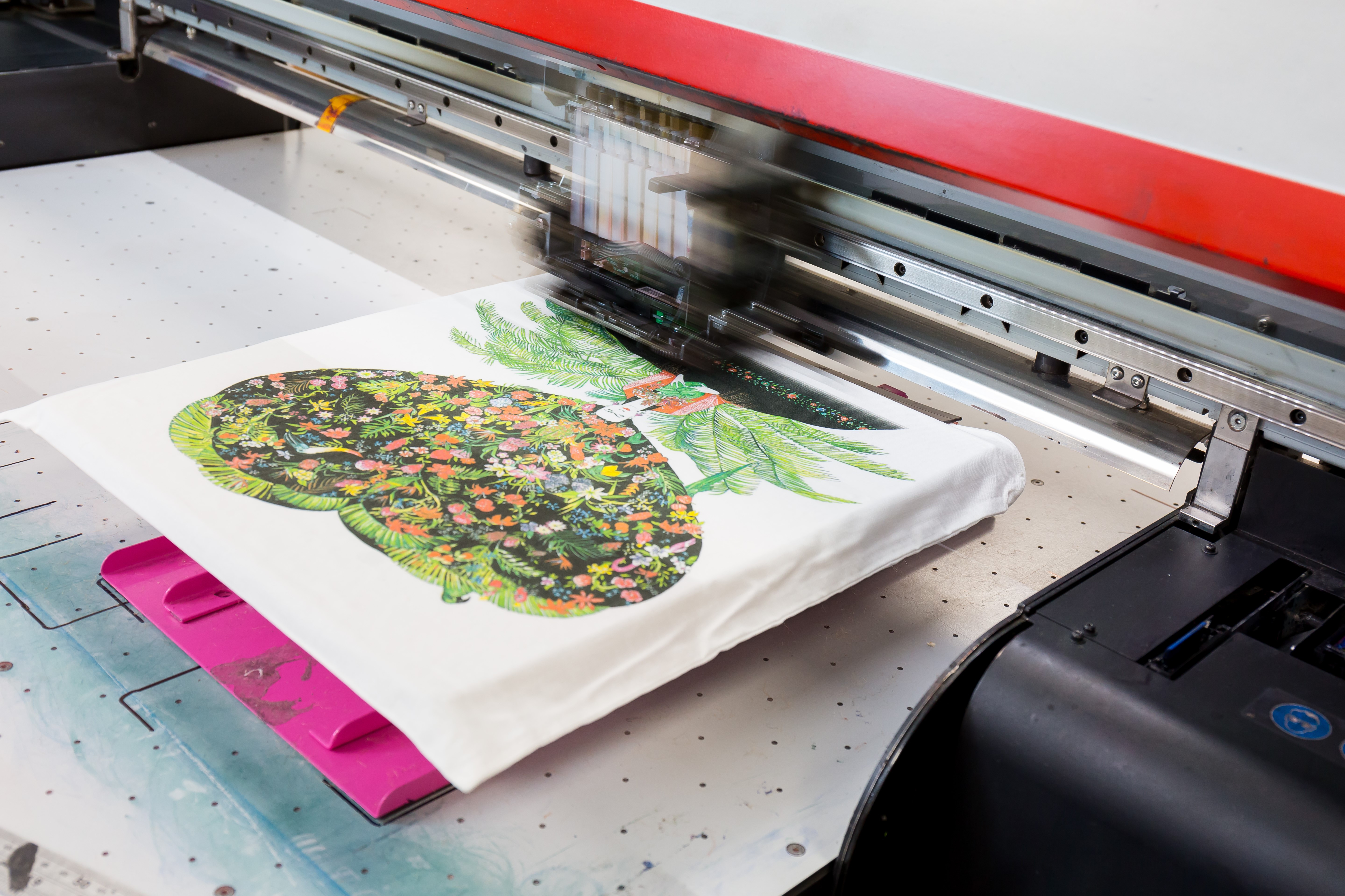 Colourful tea towel being digitally printed on a specialist ink jet printer.