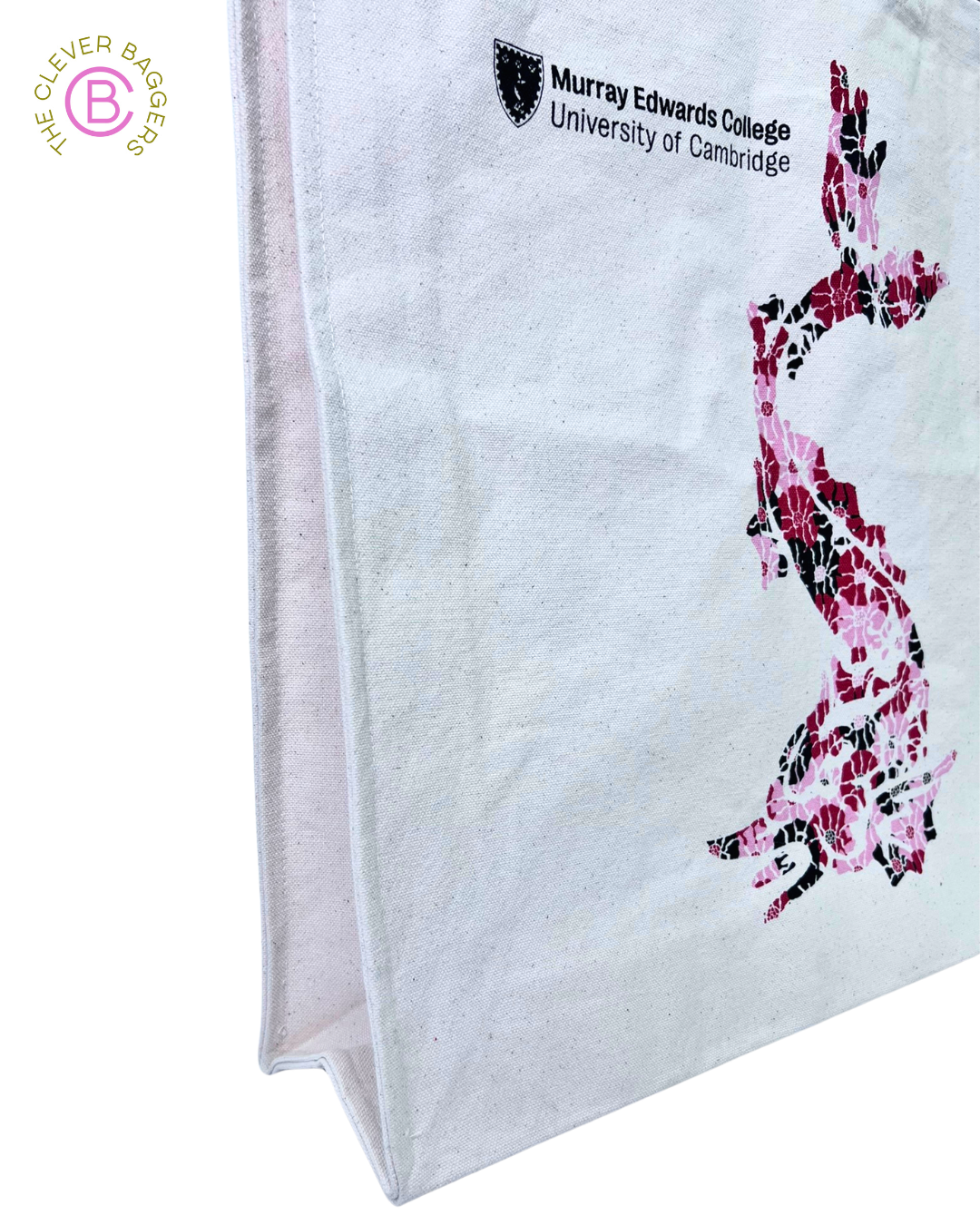 side image of a canvas tote shopper showing the guesset with a red/pink/black dragon created from flowers printed on the bag