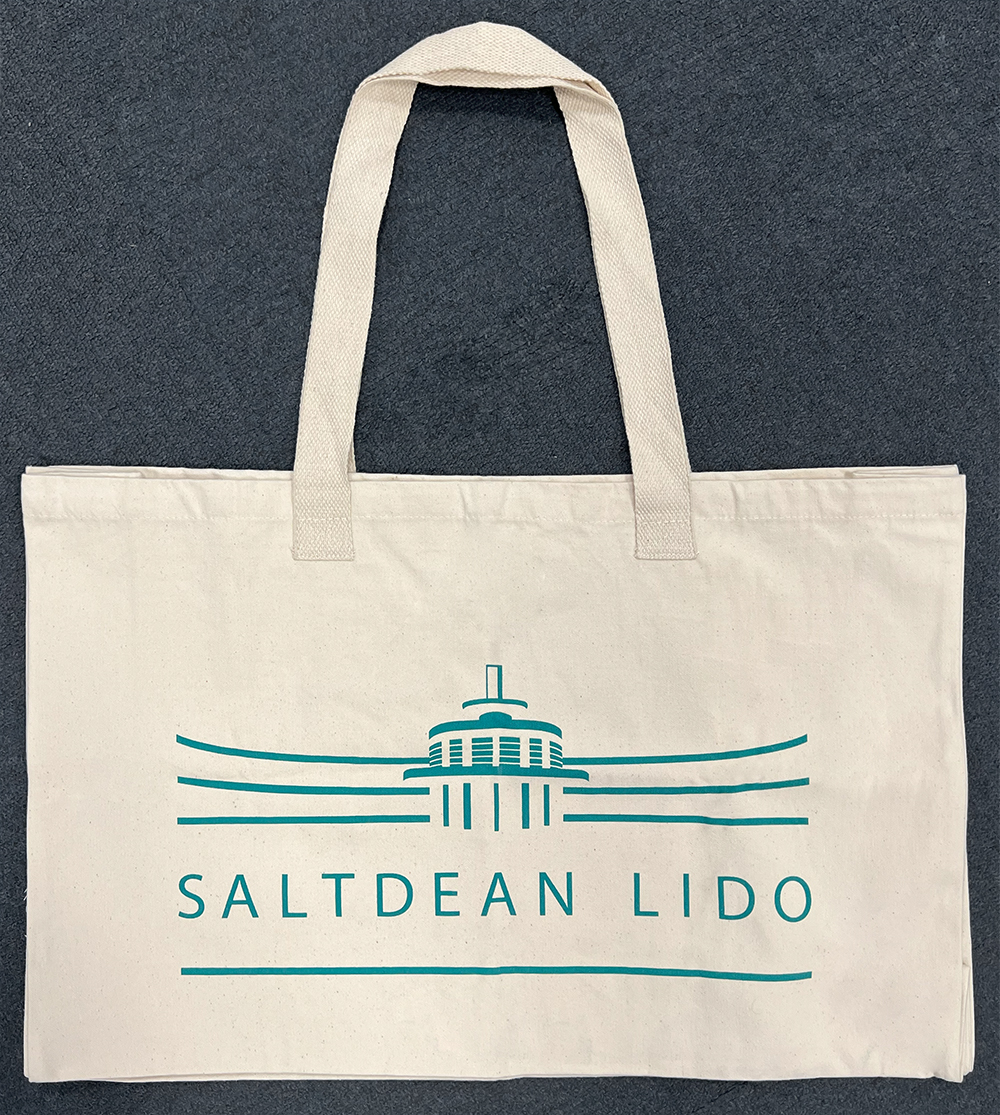 Large beige cotton canvas bag, printed with the logo of Saltdean Lido which covers most of the width of the bag. The bag is laid flat showing the length of the handles.