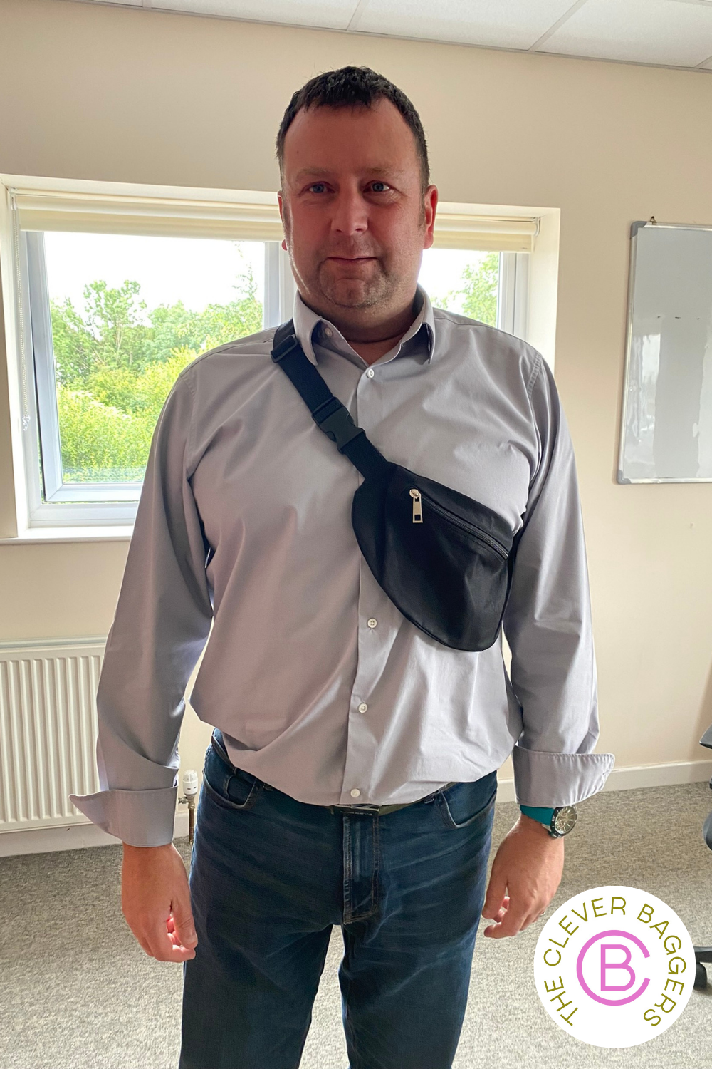 Middle aged white man wearing a bum bag slung across his shoulder.