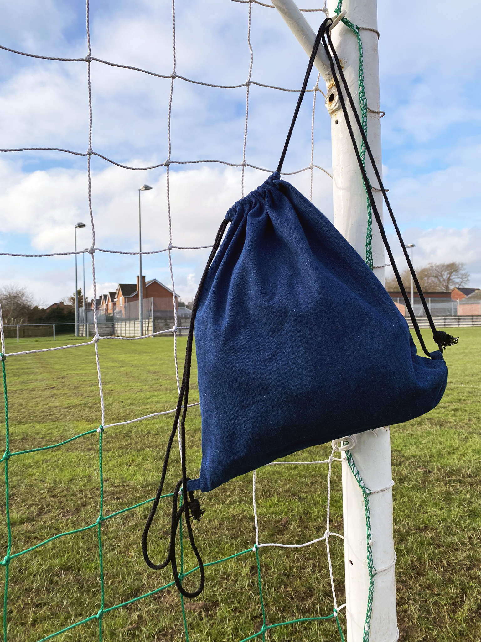 image of a plain denim cotton bag hanging in a football goal