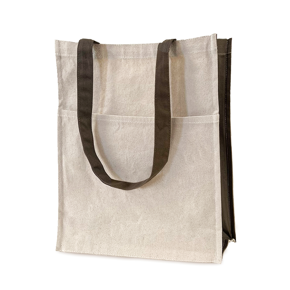 Beige tote bag with khaki green sides and handles. The bag has a full width front pocket about two-thirds the height of the bag.