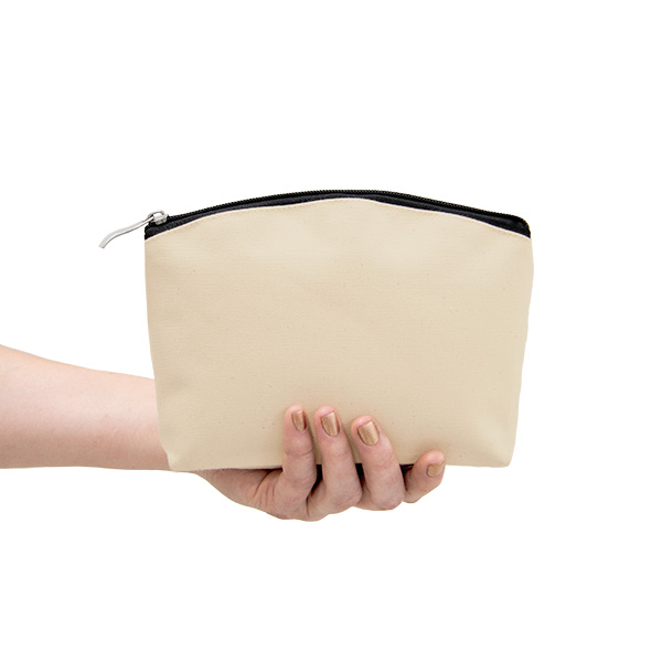 An arm holding a natural make up bag with a black coloured zipper