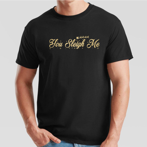 Black T-Shirt with slogan You Sleigh Me in gold effect print across the chest surrounded by tiny snowflakes and the silhouette of Santa’s sleigh pulled by a team of reindeer.