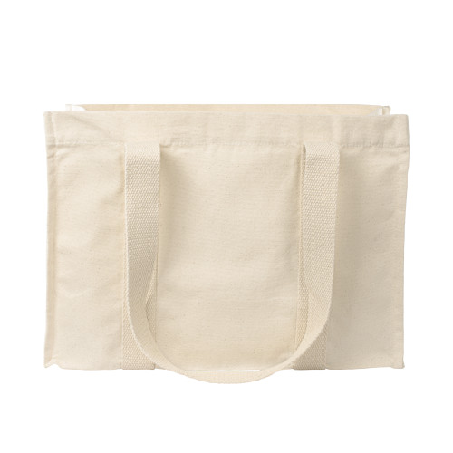 Beige canvas tote bag with medium length handles placed side on to camera to show handle length is similar to the height of the bag.